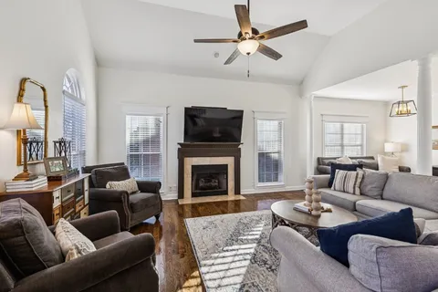 a living room with furniture a fireplace and a flat screen tv