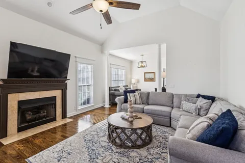 a living room with furniture a flat screen tv and a fireplace