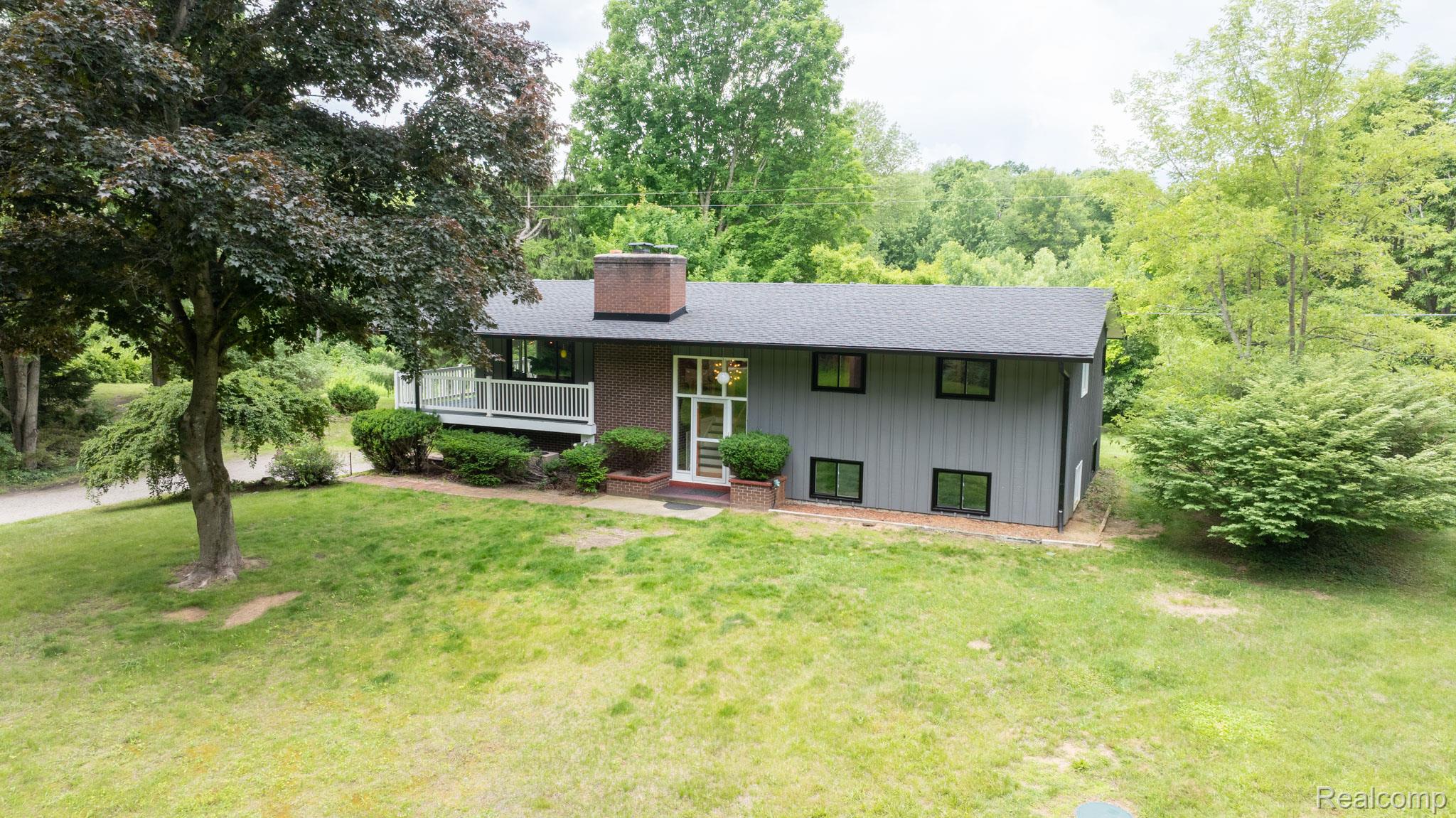 7333 Toma Road Dexter, MI 48130 - Photo 2 of 45 Contemporary exterior with gray siding and a dark shingle roof