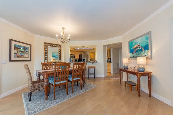 a view of a dining room with furniture a chandelier and wooden floor