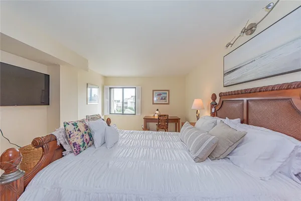 a bedroom with a bed and flat screen tv