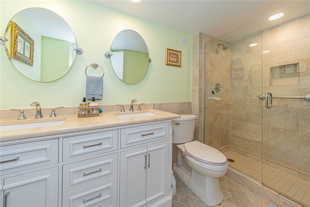 1850 Bay Road, Unit 3G Vero Beach, FL 32963 - Photo 26 of 36 a bathroom with a toilet a sink a mirror and vanity