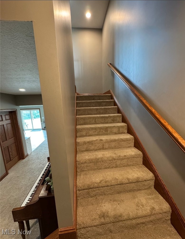 49402 Patton Road Jerusalem, OH 43747 - Photo 27 of 28 Staircase with carpet floors and a textured ceiling