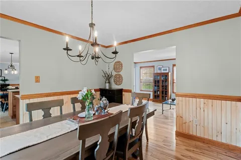 a view of a dining room with furniture a chandelier and wooden floor