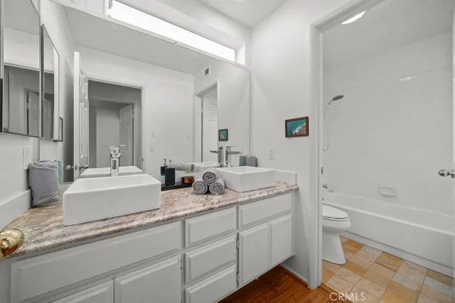 a bathroom with a granite countertop sink mirror and bathtub