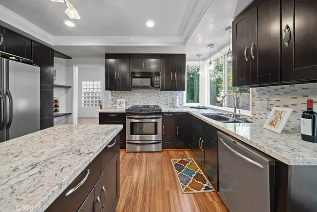 a kitchen with stainless steel appliances granite countertop a sink stove and refrigerator
