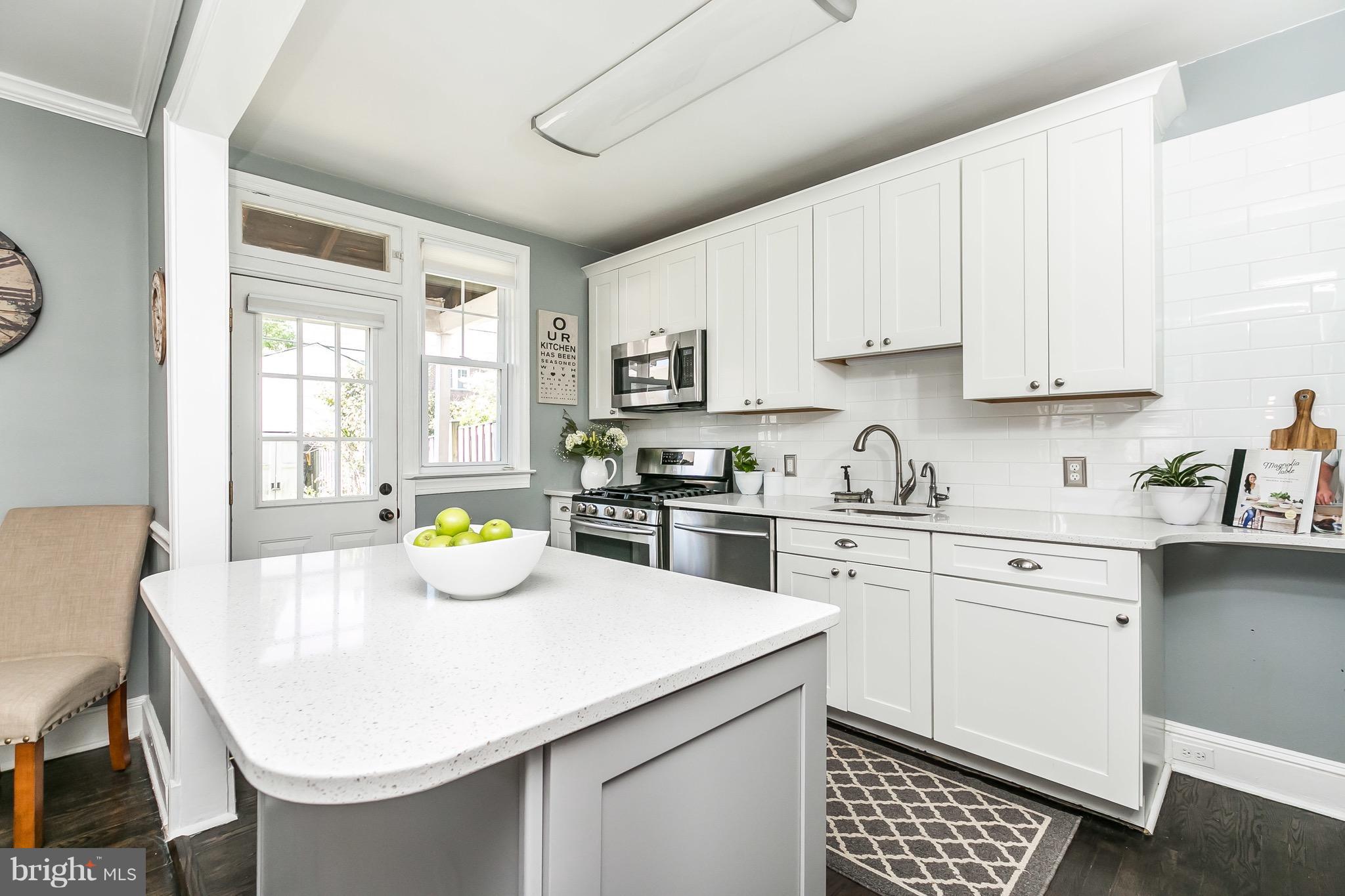 419 Hopkins Road Baltimore, MD 21212 - Photo 9 of 30 a kitchen with a sink a stove cabinets and chairs