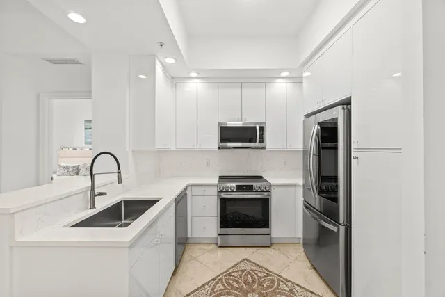 a kitchen with stainless steel appliances a stove a sink a microwave and refrigerator