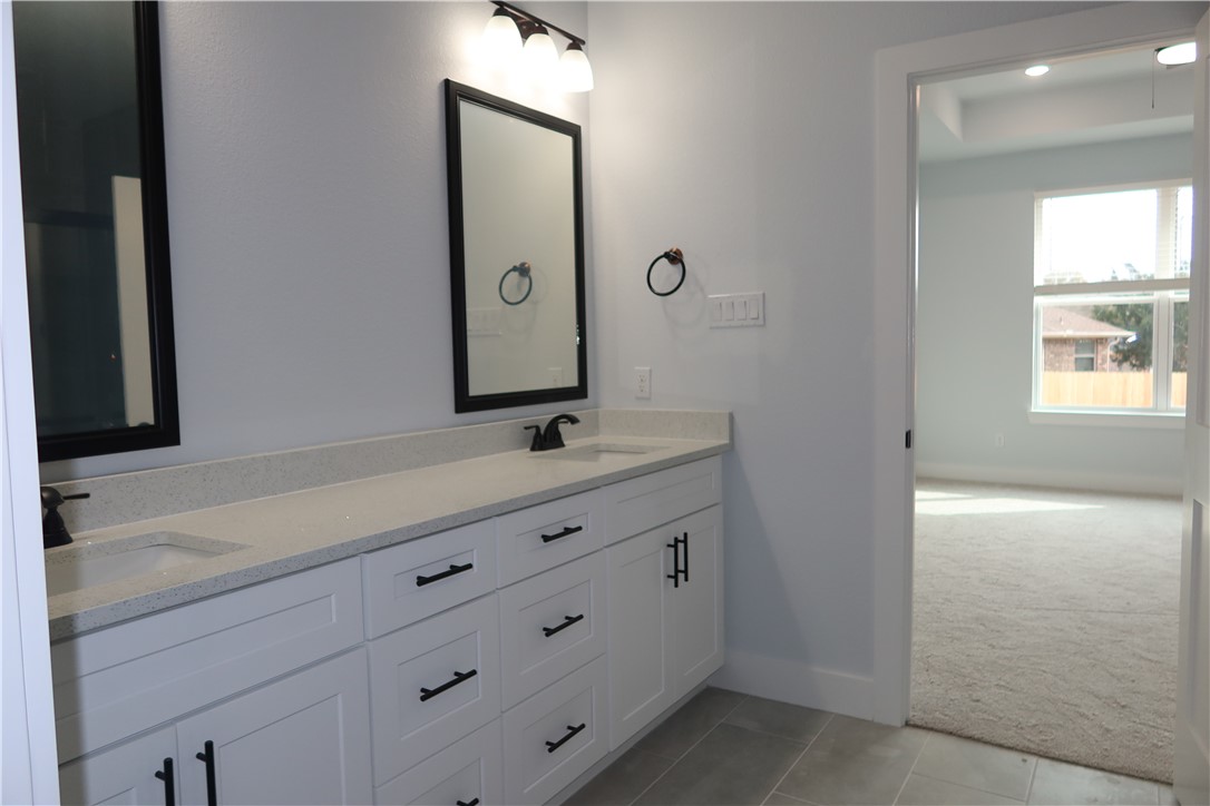 2014 Reagan Court Bryan, TX 77802 - Photo 14 of 22 a bathroom with a sink a mirror and a window