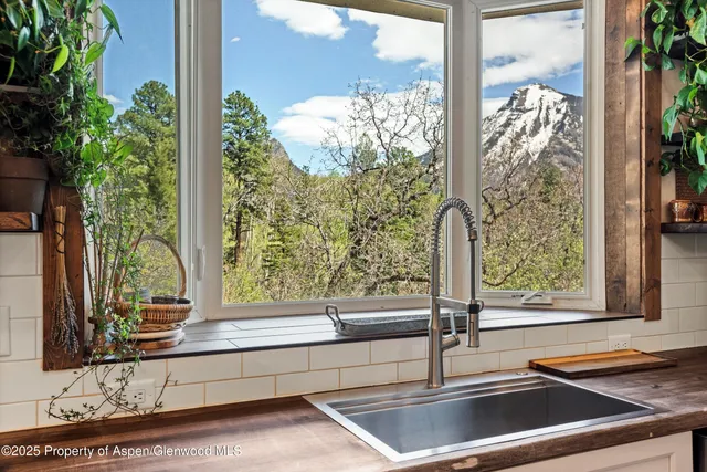 a living room with furniture a fireplace and a large window