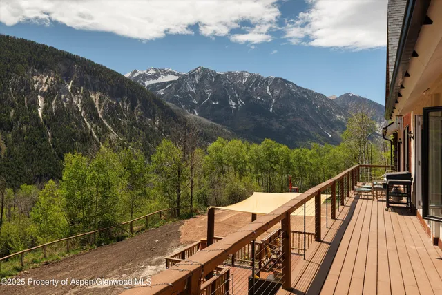 a kitchen with stainless steel appliances granite countertop a refrigerator a sink dishwasher a dining table and chairs with wooden floor