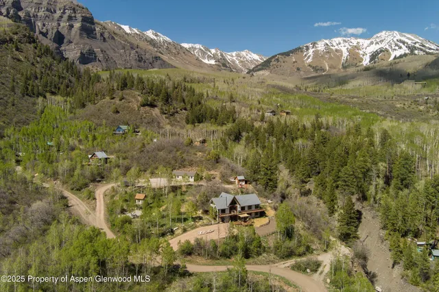 a living room with furniture kitchen area and a wooden floor