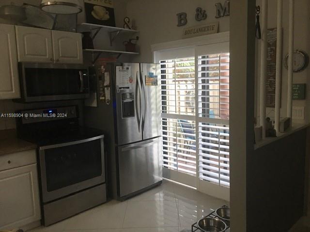 6783 Bridlewood Court, Unit 6783 Boca Raton, FL 33433 - Photo 14 of 56 a kitchen with a refrigerator cabinets and a window