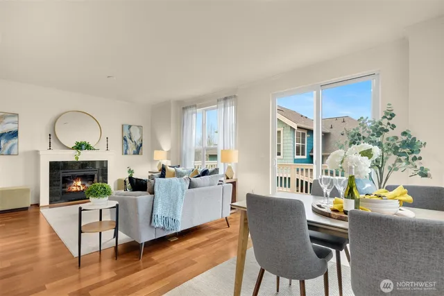 a living room with furniture a fireplace and a dining table with wooden floor
