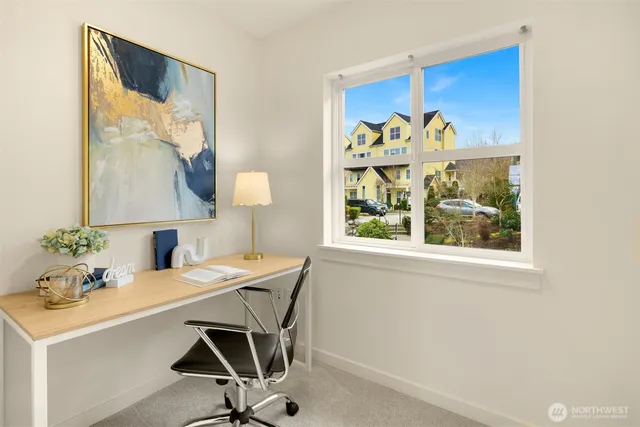 a view of a workspace with furniture and a window