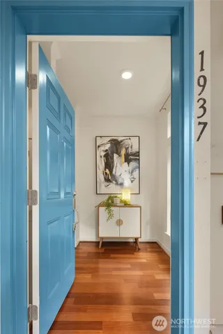 a hallway with painting on the wall and a large mirror