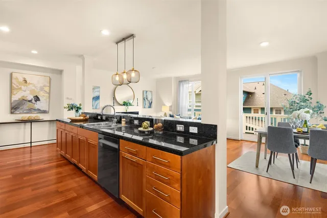 a kitchen with stainless steel appliances granite countertop a stove a sink and a wooden floors