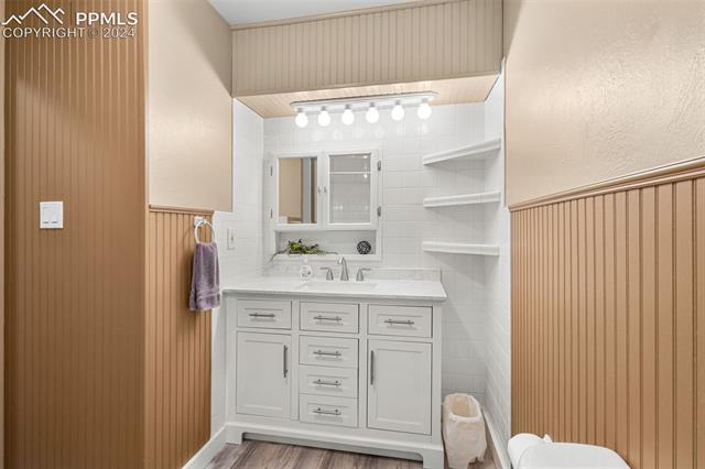 2125 Winston Road Colorado Springs, CO 80909 - Photo 19 of 37 Bathroom with hardwood / wood-style flooring, vanity, and toilet