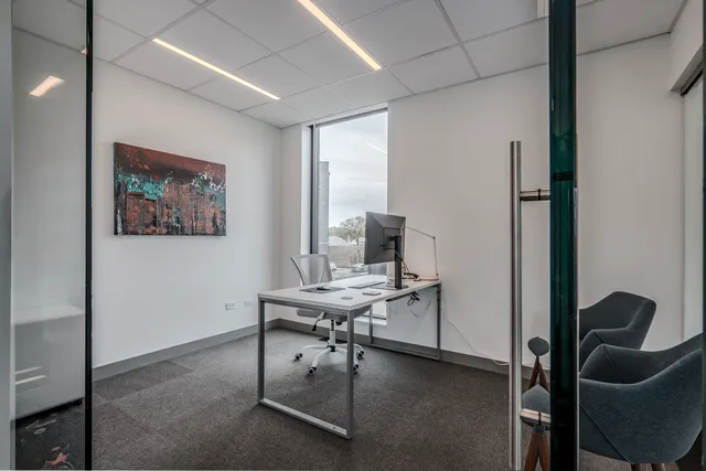 a view of a workspace with furniture and a window