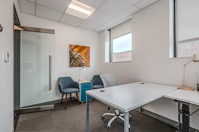 a view of a workspace with furniture and a window