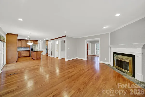a view of empty room with wooden floor and fireplace
