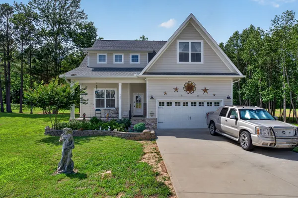 a front view of a house with a garden and trees