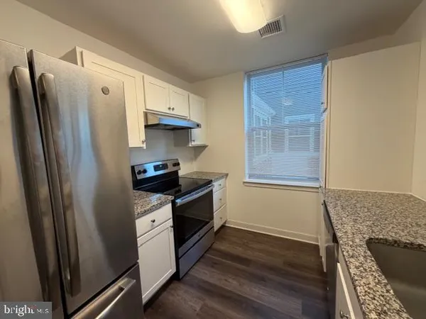 a kitchen with stainless steel appliances granite countertop a refrigerator and a stove