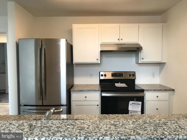 a kitchen with stainless steel appliances granite countertop a refrigerator a stove and a sink