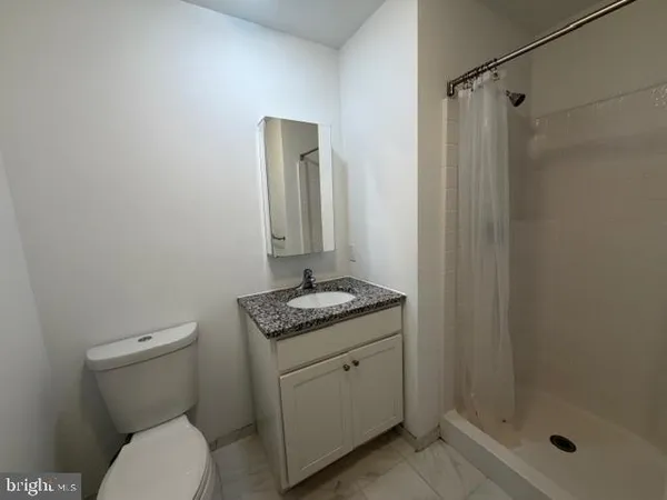 a bathroom with a granite countertop toilet sink and shower