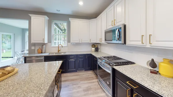 a kitchen with granite countertop a sink a stove and cabinets