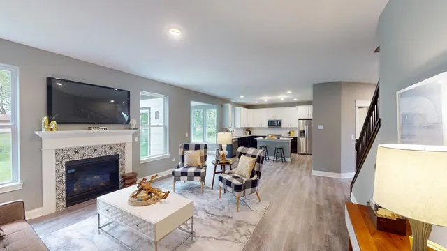 a living room with furniture a flat screen tv and a fireplace