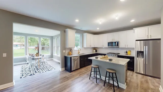 a large kitchen with kitchen island a dining table and chairs