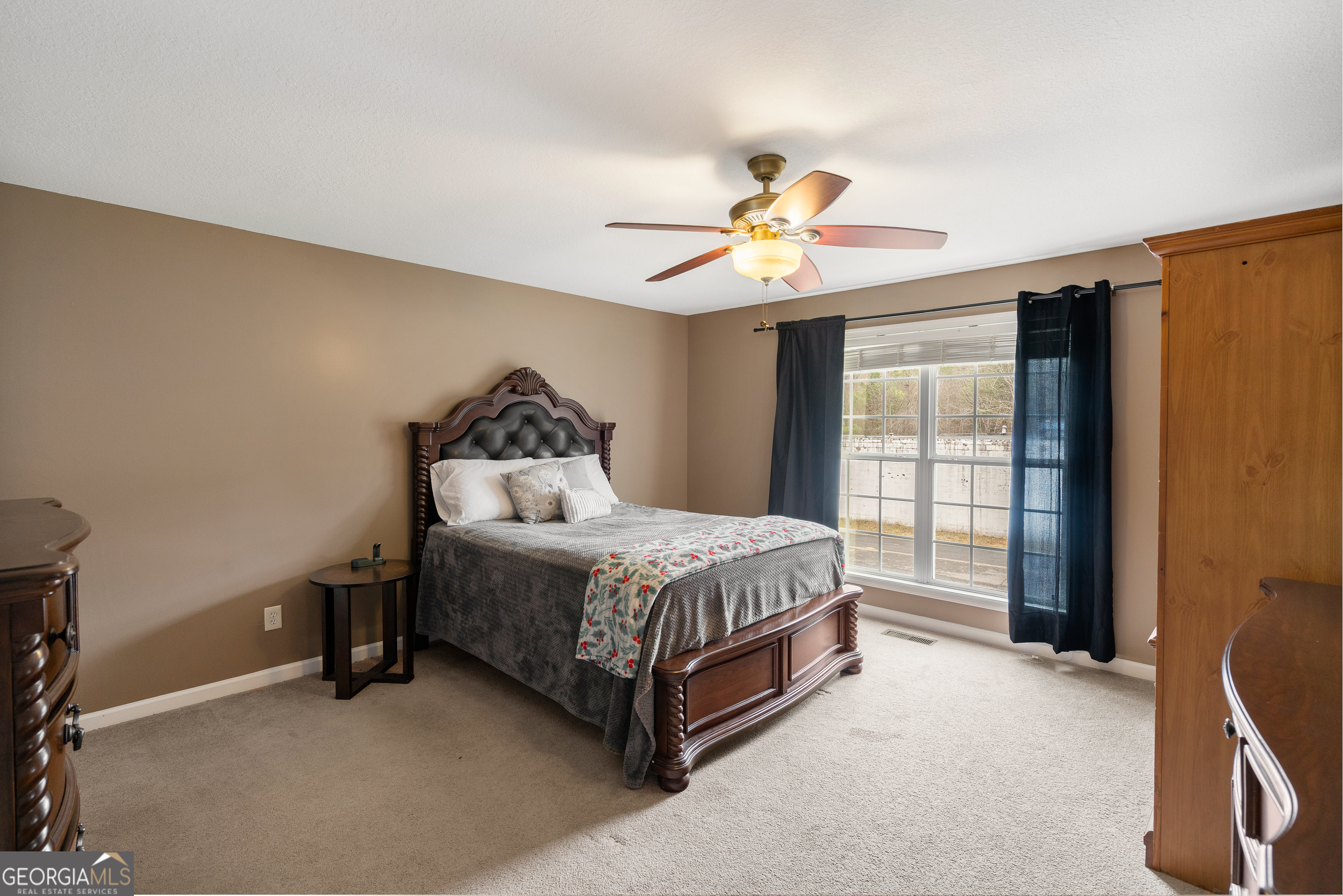 80 Columbus Street Chatsworth, GA 30705 - Photo 20 of 40 a spacious bedroom with a bed and a chandelier