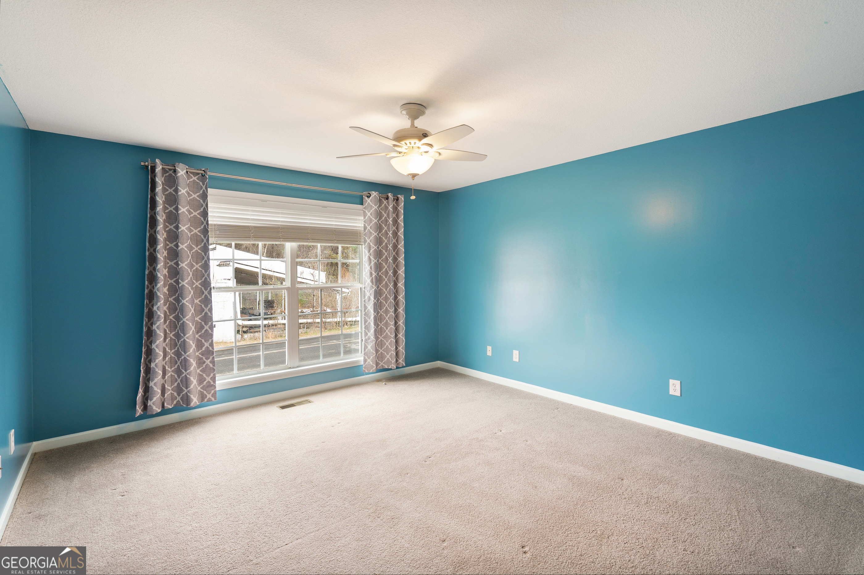 80 Columbus Street Chatsworth, GA 30705 - Photo 26 of 40 an empty room with a ceiling fan and a window
