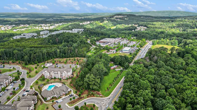 an aerial view of residential houses with outdoor space and trees