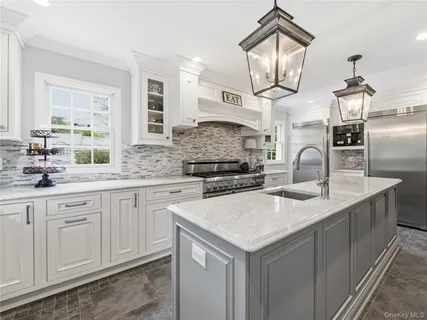a kitchen with granite countertop a sink a stove and cabinets