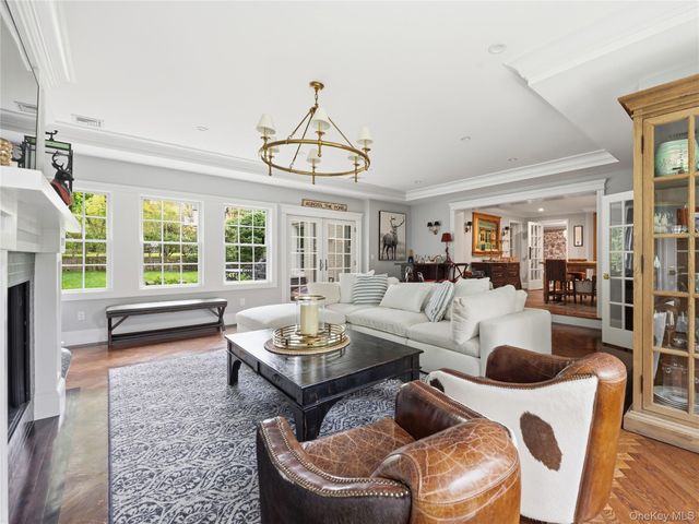 a living room with furniture a fireplace and a chandelier