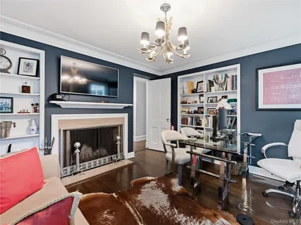 a living room with furniture a flat screen tv and kitchen view