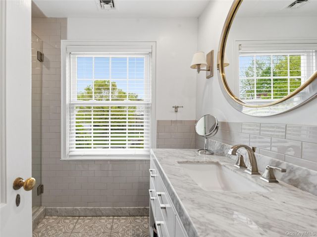 a bathroom with a granite countertop sink a window and a mirror