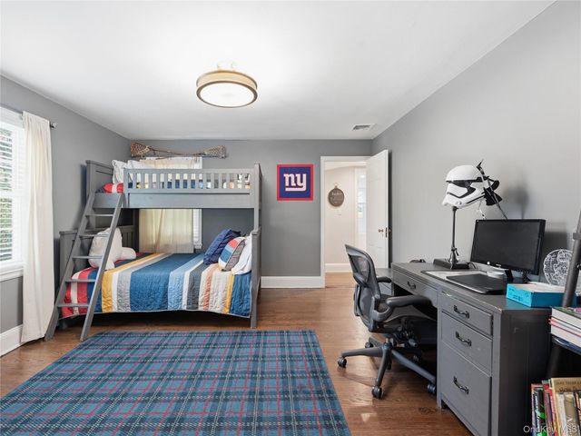 a bedroom with furniture and a air conditioner vent