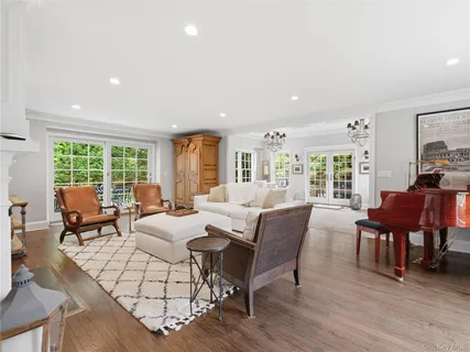 a living room with furniture large window and wooden floor