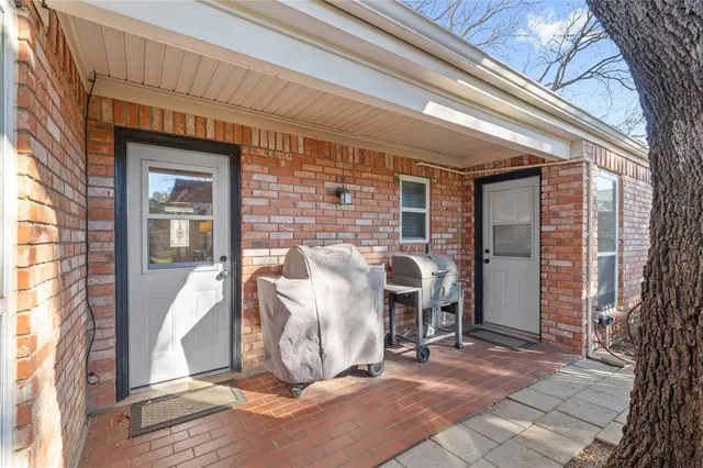 a view of a patio with table and chairs and a large tree