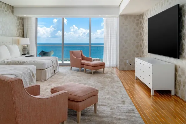 a living room with furniture a large window and a flat screen tv