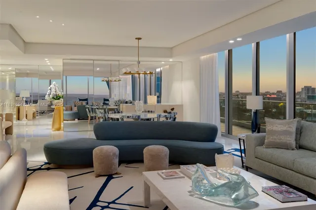 a living room with furniture kitchen view and a chandelier
