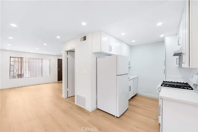 a view of kitchen with refrigerator and window