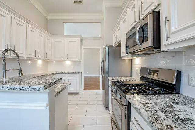 a kitchen with stainless steel appliances granite countertop a stove and a sink