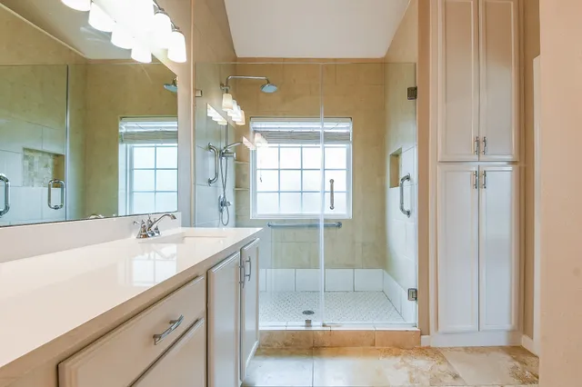 a bathroom with a sink a mirror and a shower