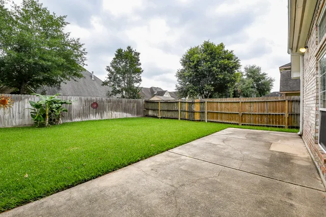 a view of yard with grass and wooden fence