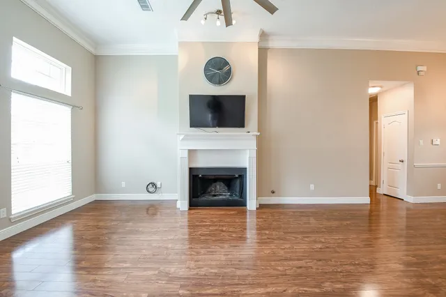 a view of a livingroom with wooden floor and a fireplace