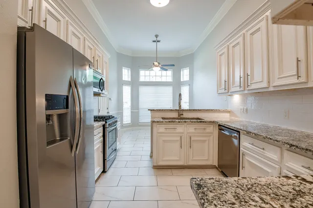a kitchen with stainless steel appliances granite countertop a sink stove and refrigerator